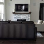 Family room tv mounted above fireplace with in-wall speakers