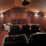 Home theater with a drop down screen and surround sound, controlled by Control4 system